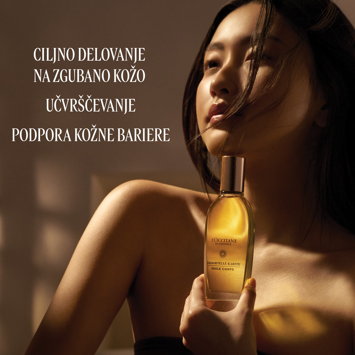 Ženska, ki drži v roki Olje za pomlajeno kožo telesa Immortelle in Karite L'Occitane