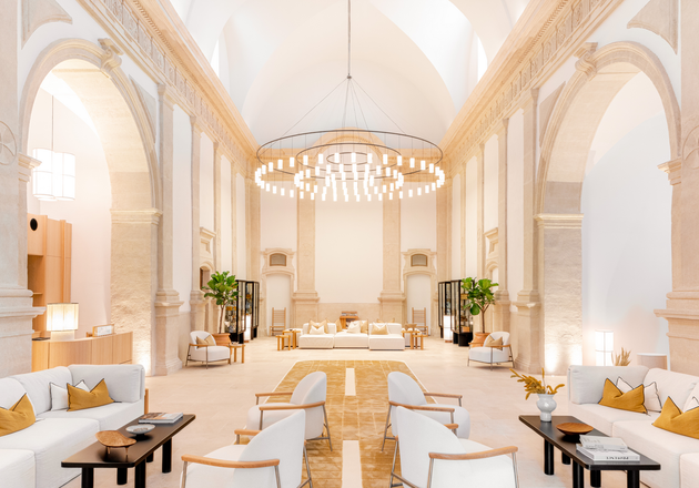 Preddverje velike svetle hiše, kjer je veliko miz, belih stolov in sedežnih garnitur - L'Occitane.