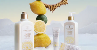 L'Occitane izdelki praznične kolekcije Lumière d’Hiver obdani s sceno snega, citrusov in belih gor v ozadju