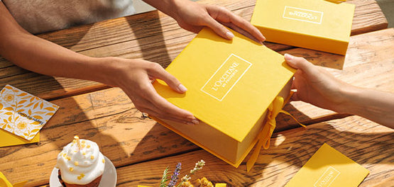 Izročanje darila v za rojstni dan – zavitega v rumeni škatli L’Occitane 

