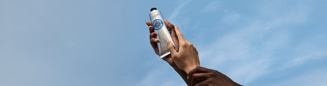 Roke dvigajo proti nebu karitejevo kremo za roke – L’Occitane 