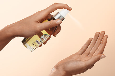 Ena roka v drugo šprica Mandljevo olje za prožno kožo L'Occitane