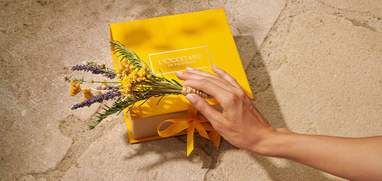 L’Occitane rumena darilna škatla, okrašena s šopkom rož 

