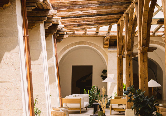 Pokrit atrij za sedet z veliko lesa in udobnimi stoli- L'Occitane