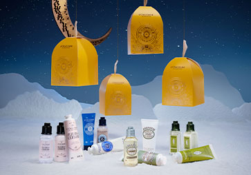 4 darila Trio Les Lumières de L'Occitane en Provence z razstavljenimi izdelki in prikazano okrasno embalažo 