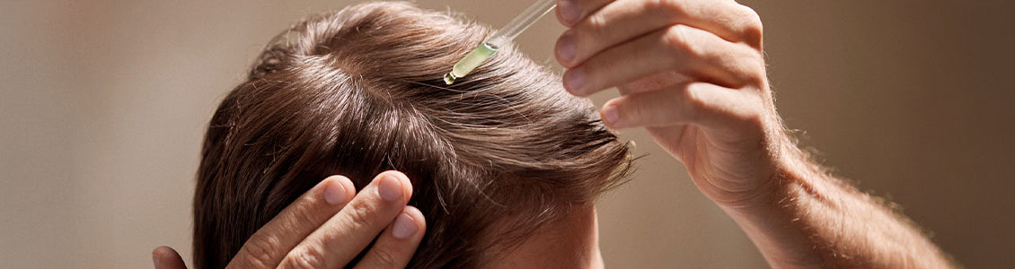 Moški si na lasišče nanaša L'Occitanov serum za lase proti izpadanju las 