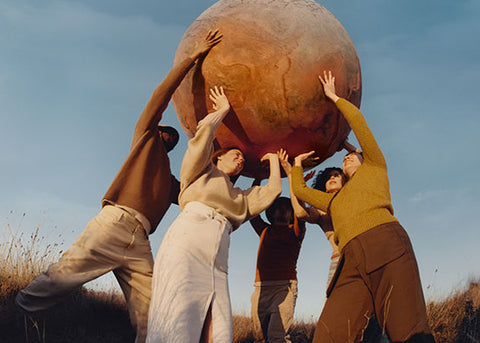 Skupina ljudi, ki drži v rokah planet Zemljo - L’OCCITANE zaveze o varovanju našega planeta in spoštovanju do človeka