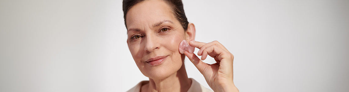 Starejša negovana ženska si z L’OCCITANOVIM pripomočkom masira obraz 