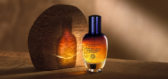 Steklenična Boosterja za nočno nego obraza Immortelle Reset v vijolični in rumeni barvi 