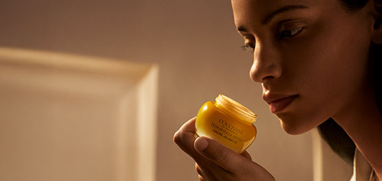 Ženska drži v rokah Božansko kremo za obraz – L’OCCITANE 