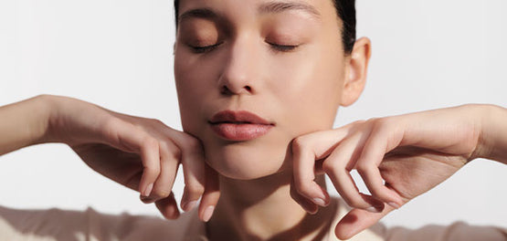 LEPOTNI NASVET  Ženska si na obraz nanaša L’Occitanovo olje za obraz 