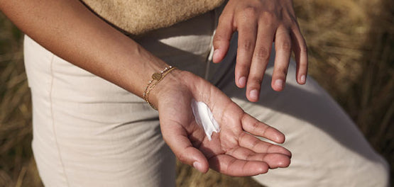 Ženska si na roke nanaša vlažilno kremo – L’Occitane  