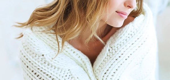 Ženska v belem pletenem puloverju